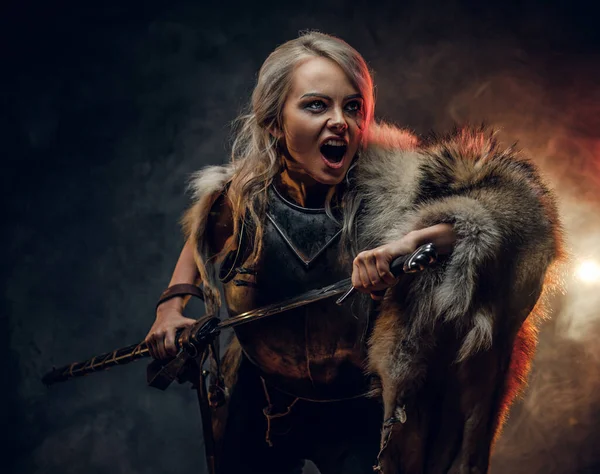 Mujer de fantasía caballero vistiendo coraza y piel, sosteniendo una espada y se apresura a la batalla con un grito furioso. Cosplayer como Ciri de The Witcher . —  Fotos de Stock