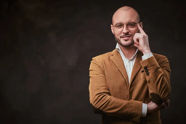 Successfull bald businessman posing in a studio wearing stylish velvet jacket, white shirt and glasses — ストック写真