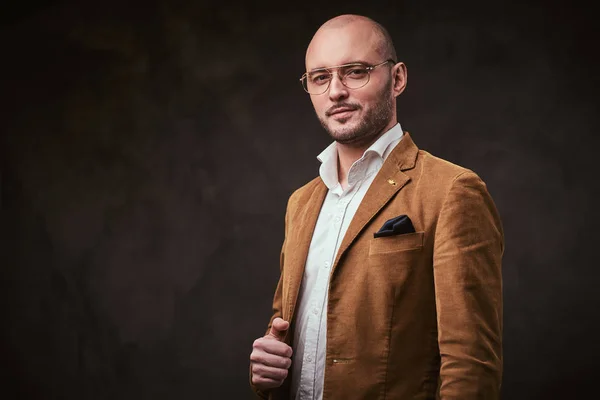 Successfull bald businessman posing in a studio wearing stylish velvet jacket, white shirt and glasses — ストック写真