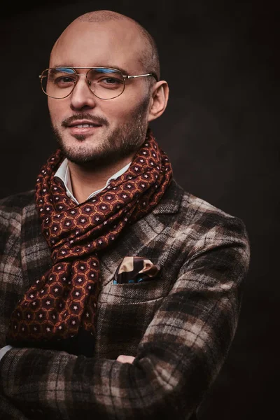 Úspěšný stylový obchodník pózující ve studiu v kostkované bundě, brýlích a šále — Stock fotografie