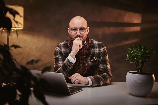 Καραφλός Ευρωπαίος καλοντυμένος σοβαρός επιχειρηματίας κάθεται στο γραφείο σε ένα τραπέζι με σημειωματάριο, φορώντας κομψό σακάκι και μαντήλι — Φωτογραφία Αρχείου