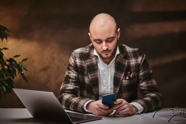 Hombre de negocios europeo calvo sentado en la oficina en una mesa con cuaderno, con chaqueta elegante, camisa . —  Fotos de Stock