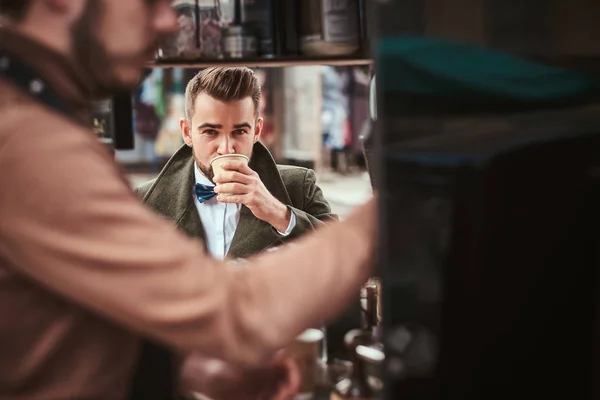 Elegante cliente masculino sentado al aire libre junto a barista en una cafetería móvil en un emporio de la ciudad — Foto de Stock