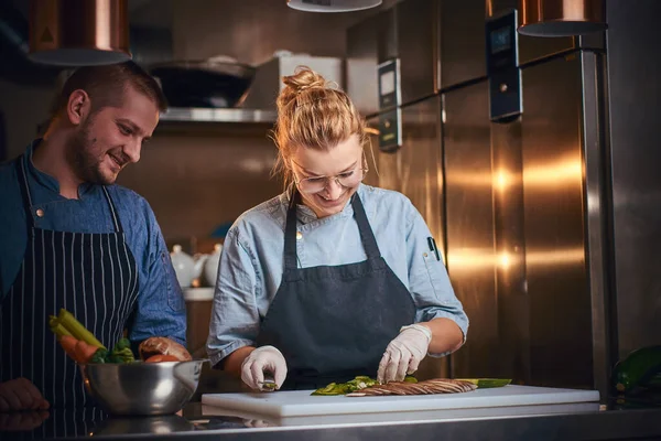 Chefe masculino com assistente de pé em uma cozinha, preparando comida em um restaurante de luxo — Fotografia de Stock