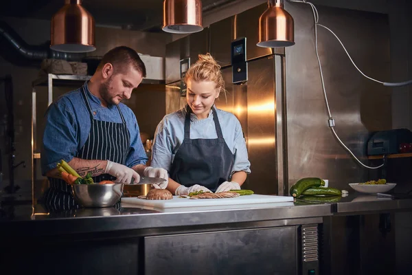 Chefe masculino com assistente de pé em uma cozinha, preparando comida em um restaurante de luxo — Fotografia de Stock