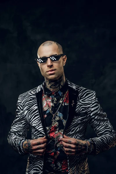 Framgångsrik tatuerad, skallig modern manlig modell poserar i en mörk studio för fotografering, tittar på kameran — Stockfoto