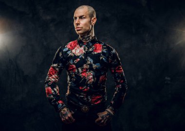 Ciddi dövmeli, kel haute erkek model fotoshoot için stüdyoda poz veriyor.