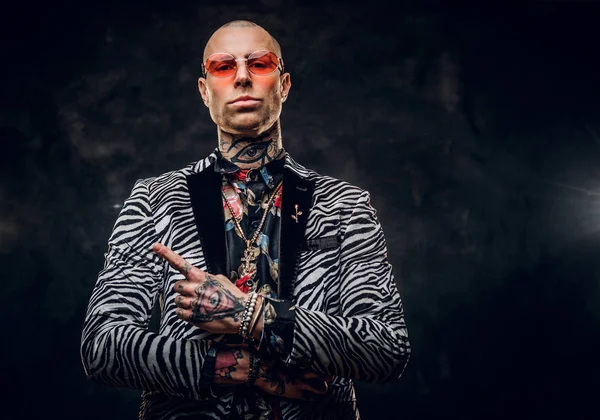 Brutal tatuado, calvo modelo masculino de moda posando en un estudio para el estilo de moda de sesión de fotos mostrando un gesto con un dedo y mirando en serio — Foto de Stock