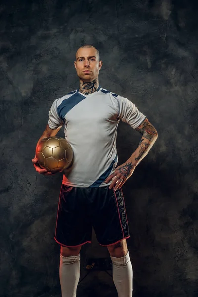 Hot tattooed, bald fashionable male soccer player posing in a studio for the photoshoot with a soccer ball — Stock Photo, Image