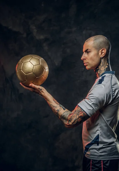 Horké tetované, plešatý módní mužský fotbalista pózující ve studiu pro focení s fotbalovým míčem — Stock fotografie