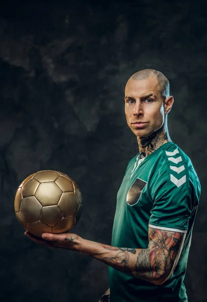 Hot tattooed, bald fashionable male soccer player posing in a studio for the photoshoot with a soccer ball — Stock Photo, Image