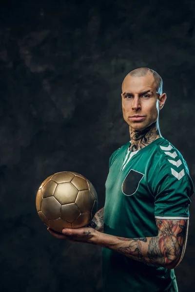 Masculine tattooed, bald fashionable male soccer player posing in a studio for the photoshoot with a soccer ball — Stock Photo, Image