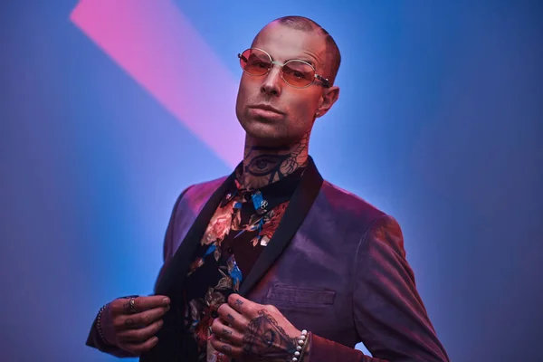 Confident tattooed, bald fashionable male model posing in a studio for the photoshoot vogue style showing a gesture with arms — Stock Photo, Image