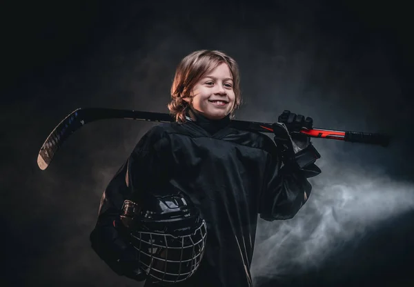 Young smiling hockey player posing in uniform for a photoshot in a studio — Stock Photo, Image