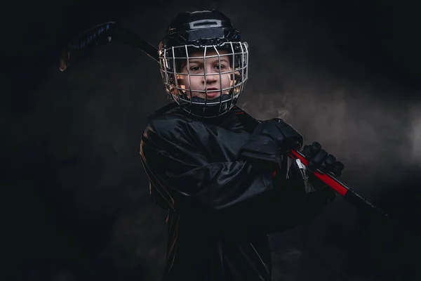 8-10 year old smiling hockey player posing in uniform for a photoshot in a studio — Stockfoto