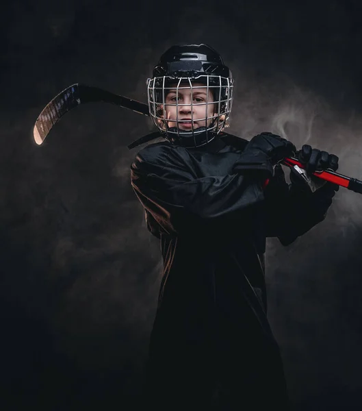 Menino de 8-10 anos, jogador de hóquei menino posando em uniforme com equipamento de hóquei para um photoshot em um estúdio — Fotografia de Stock