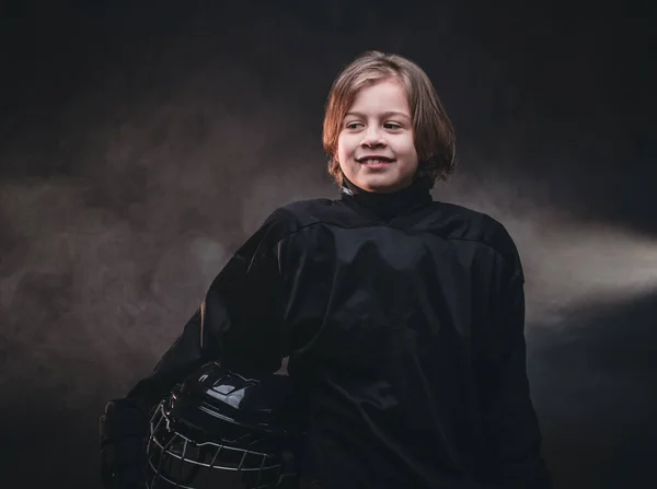 8-10 year old boy, hockey player boy posing in uniform with hockey gear for a photoshot in a studio — Stockfoto