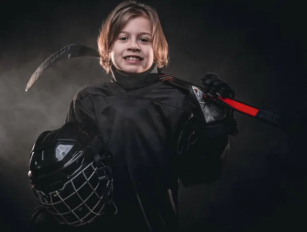 Giovane giocatore di hockey sorridente in posa in uniforme da hockey per una foto in uno studio — Foto Stock