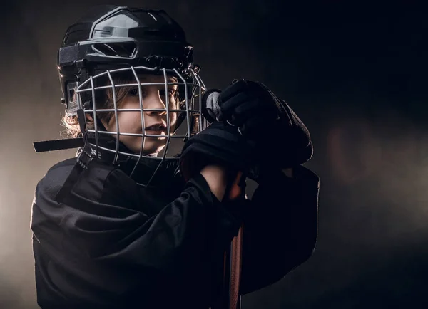 Молодой улыбающийся хоккеист позирует в форме для фотосессии в студии — стоковое фото