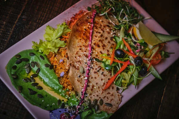 Deliciosa comida vegetariana que incluye tortitas llenas de arroz, verduras al vapor mezcladas servidas en un plato de porcelana blanca con unción verde y hierbas —  Fotos de Stock