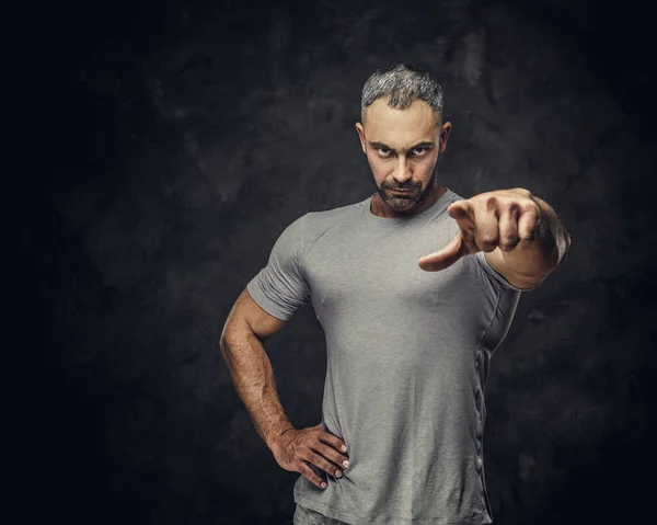 Взрослый кавказский мускулистый культурист показывает жест рукой и смотрит сердито на камеру, портретный взгляд — стоковое фото