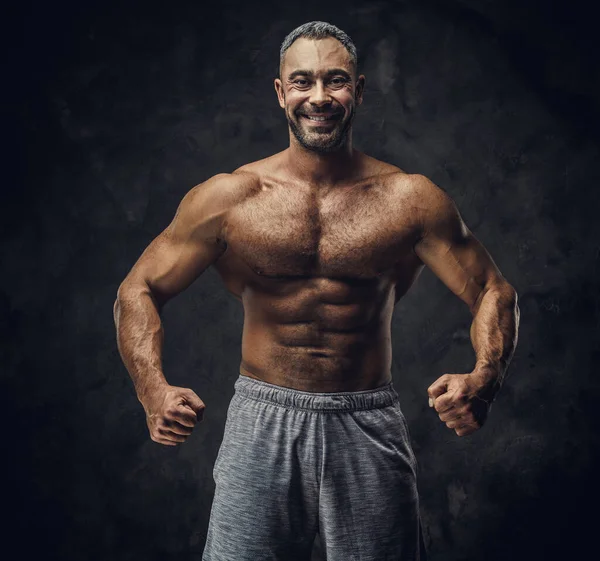 Adult caucasian muscular bodybuilder showing his muscles and looking on camera, portrait look — Zdjęcie stockowe