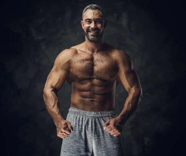 Adult caucasian muscular bodybuilder showing his muscles and looking on camera, portrait look — ストック写真