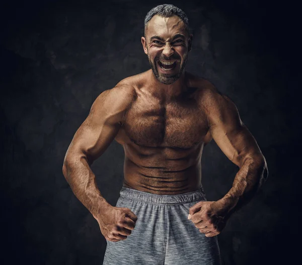 Adulto caucasiano musculoso fisiculturista mostrando seus músculos e olhando para a câmera, olhar retrato — Fotografia de Stock