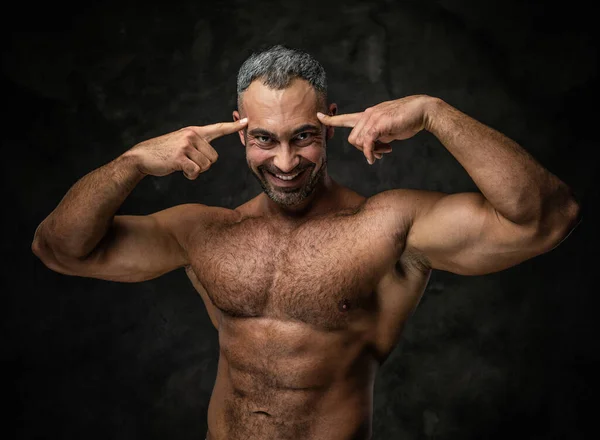 Adult caucasian muscular bodybuilder showing his muscles and looking on camera, portrait look — Stockfoto