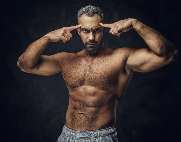 Adult caucasian muscular bodybuilder showing his muscles and looking on camera, portrait look — Stockfoto