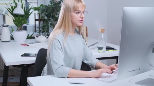 Приваблива дівчина працює в офісі — стокове відео
