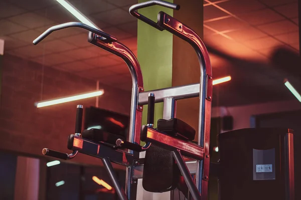 Metallic parallel bar machine standing in an empty modern fitness center. — Zdjęcie stockowe