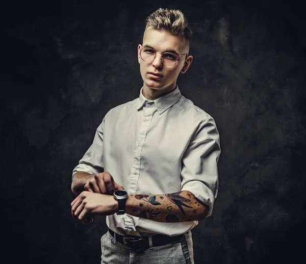 Good looking, young adult male student looking serious checking his watches in a studio, isolated on a grey background — Stock Photo, Image