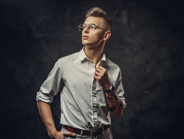 Boshaft aussehender junger erwachsener Mann posiert in einem Studio, isoliert auf grauem Hintergrund — Stockfoto