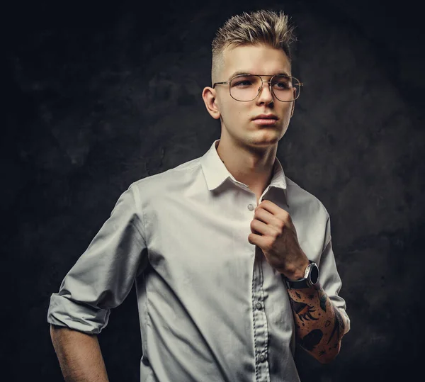 Hipster op zoek naar jonge volwassen man poseren in een studio, op zoek rustig, geïsoleerd op een grijze achtergrond — Stockfoto