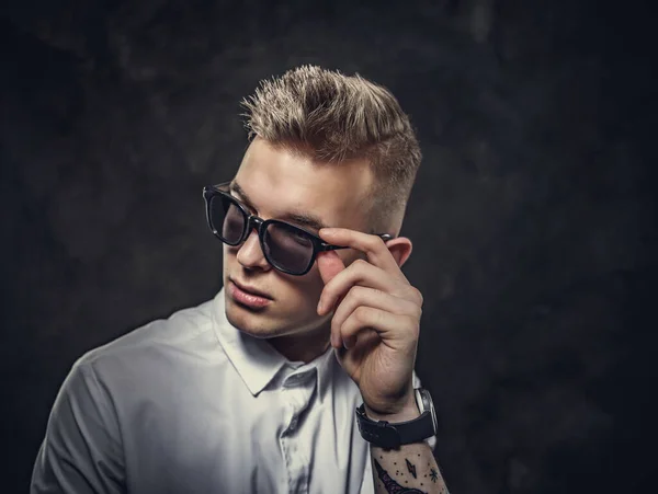 Hipster cerca giovane maschio adulto in piedi in uno studio in una posa curiosa e interessata, isolato su uno sfondo grigio — Foto Stock