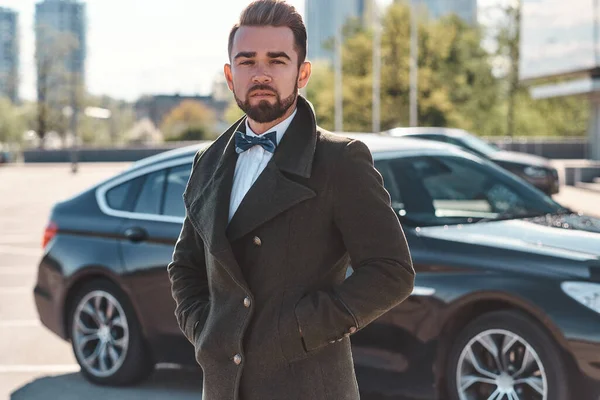 Jovem bonito adulto empresário em pé ao ar livre perto de seu carro, close up retrato — Fotografia de Stock