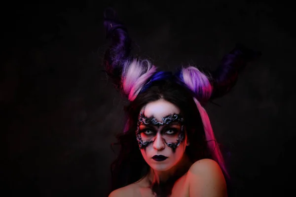 Giovane donna che indossa mistico scuro make-up e corna viola posa in uno studio per un cosplay — Foto Stock