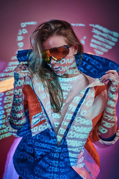 Közelkép egy fiatal tetovált versenyző nőről, aki egy élénk neon stúdióban pózol szövegvetítés közben. — Stock Fotó