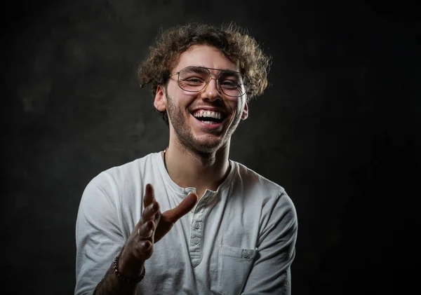 Schöner und lässig aussehender Mann posiert für das Fotoshooting auf dem dunklen Hintergrund und lacht — Stockfoto