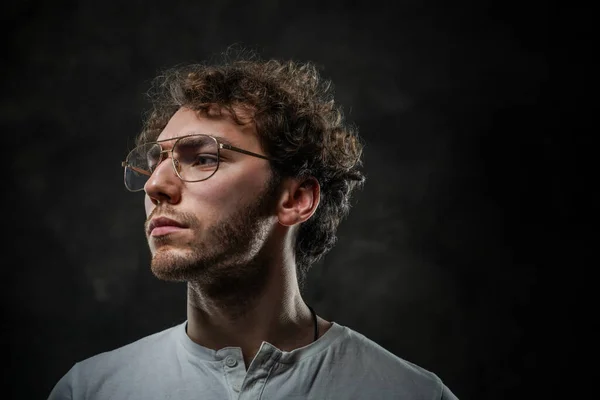 Estudiante serio usando ropa casual y amuleto posando en el estudio para una sesión de fotos — Foto de Stock