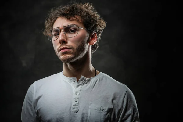 Serious and thoughtful student posing on a dark background in the studio — Stock Photo, Image