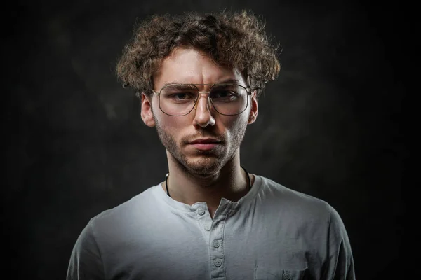 Serious and thoughtful student posing on a dark background in the studio looking sceptical — Stock Photo, Image