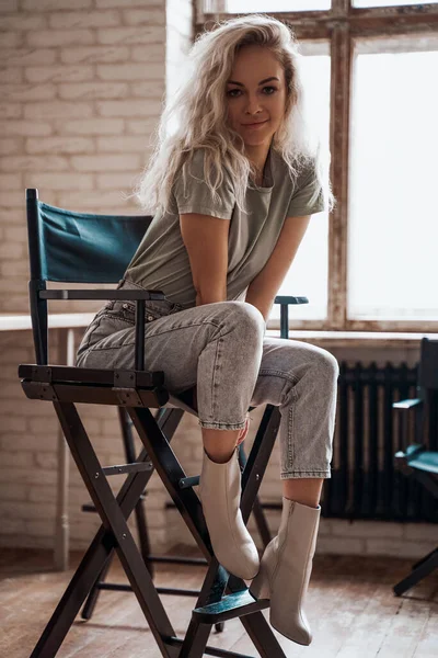 Nyugodt és divatos nő szőke hajjal pózol egy sminkes stúdióban — Stock Fotó