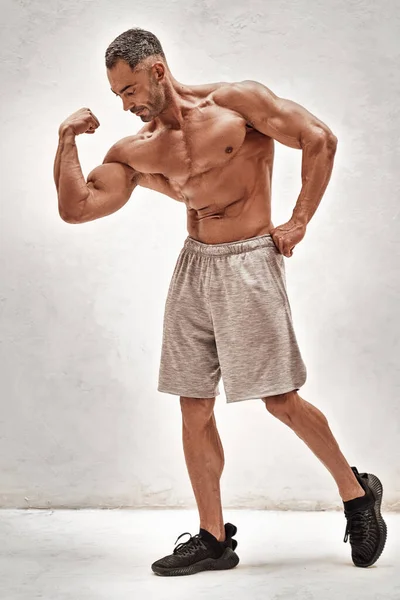Silný Dospělý Sportovec Ukazuje Své Napumpované Biceps Jasném Studiu Sobě — Stock fotografie