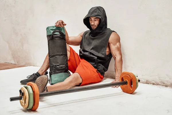 Brutal Muscular Bodybuilder Relaxing Floor Wearing Hood Red Shorts While — Stock Photo, Image