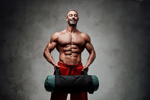 Hombre Atlético Haciendo Ejercicio Bíceps Con Una Bolsa Peso Aislada — Foto de Stock