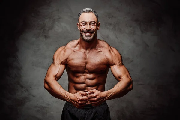Usmívající Energický Fitness Trenér Vypadá Vesele Ukazuje Své Svaly Tmavém — Stock fotografie