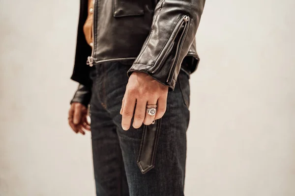 Foto de cerca de la mano masculina con dos anillos y abrigo de cuero sobre el fondo blanco —  Fotos de Stock