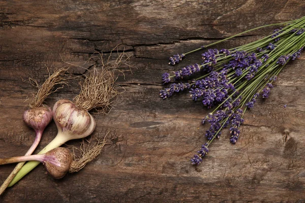 Lavender and garlic on old wooden background — Stock Photo, Image